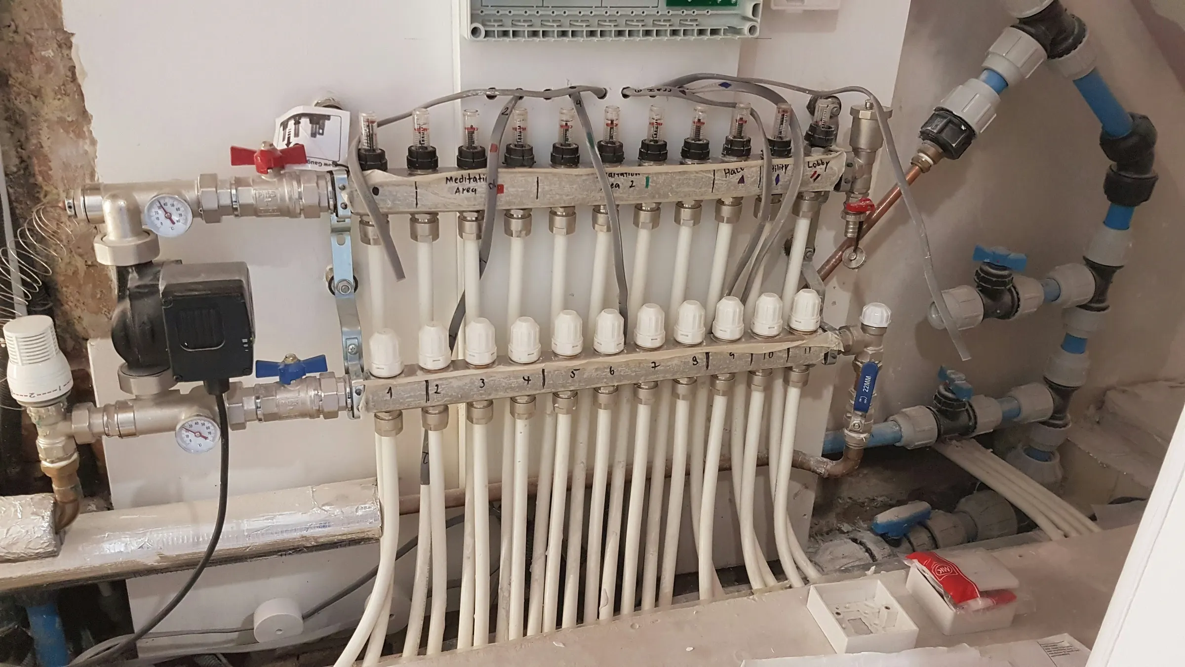Underfloor heating manifold with labelled zone pipework