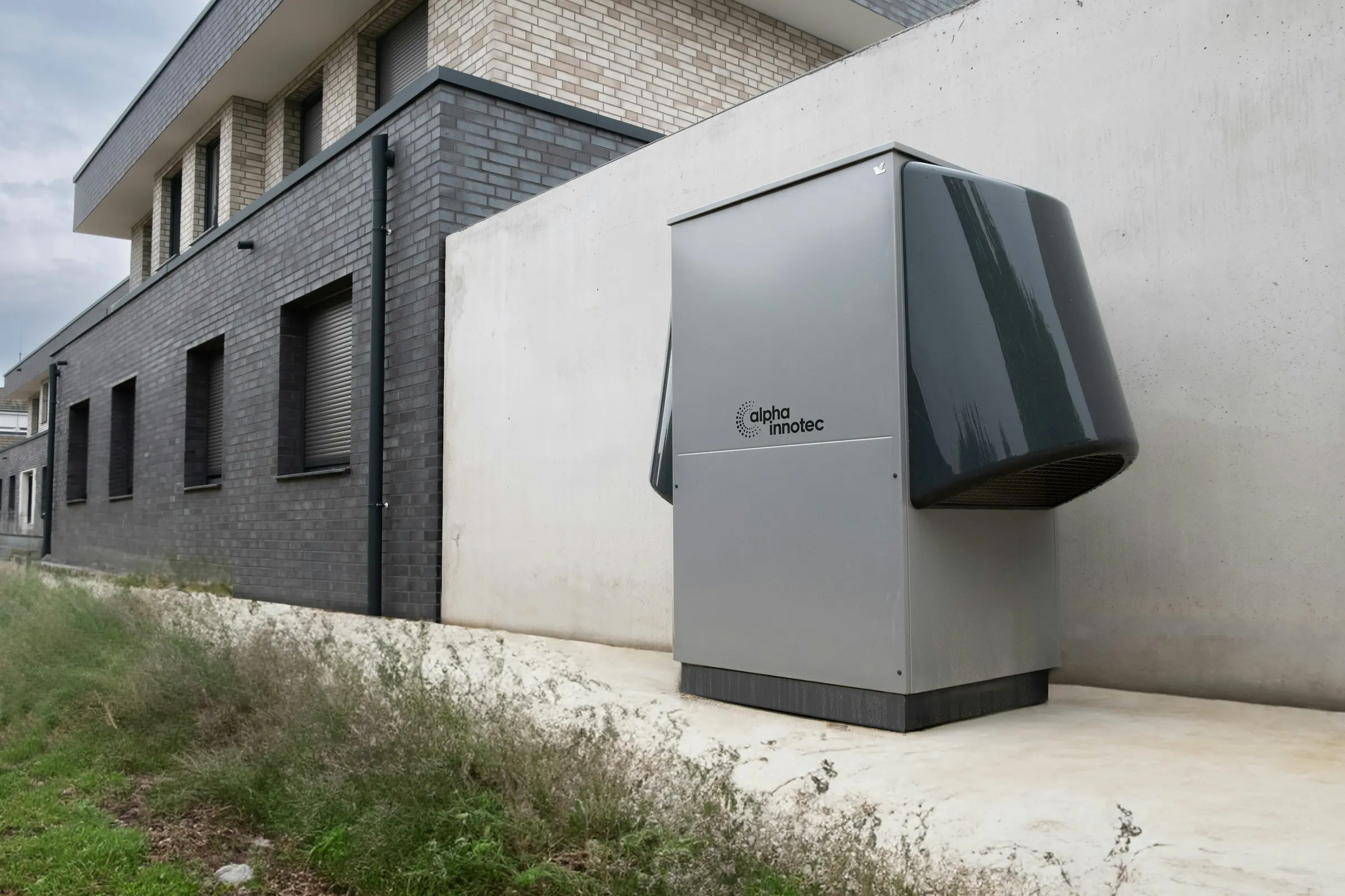 Alpha innotec heat pump installed outside a modern building