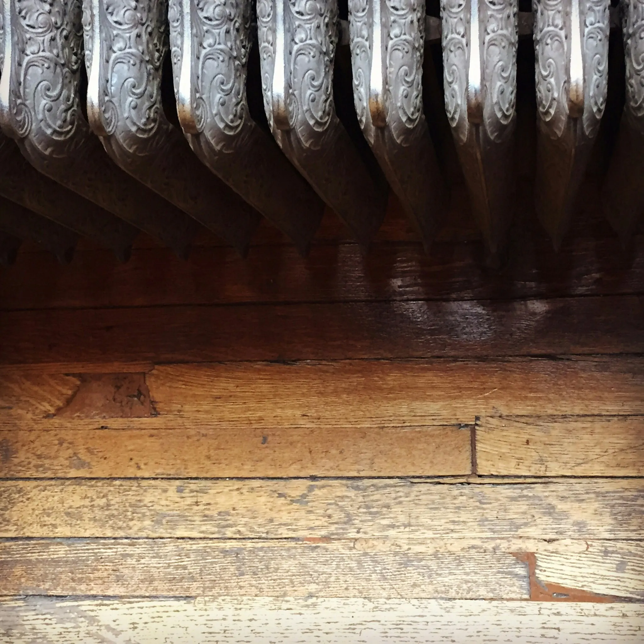 Ornate cast iron radiator above a wooden floor